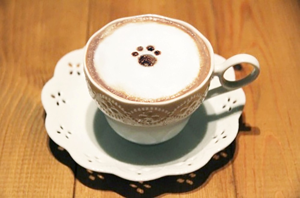 Cat Cafe 手毬之家的經典飲品：貓肉球咖啡拿鐵。可愛的餐點設計與咖啡香氣，帶來冬天暖呼呼的視覺與味覺雙重享受。©吉祥寺プティット村